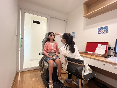 Ăn đúng cách cũng có thể phòng chống bệnh cận thị- Ảnh 1. Một em nhỏ bị cận thị được ba mẹ đưa đi đo mắt kính - Ảnh: MỸ DUNG
