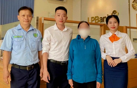 Nhóm lừa đảo tung ‘chiêu’ cũ, người phụ nữ vẫn suýt mất hơn 80 triệu đồng- Ảnh 1. Bà X. (áo xanh) được cán bộ nhân viên Ngân hàng Bưu điện Liên Việt giúp đỡ nên không bị lừa đảo mất hơn 80 triệu tiền tiết kiệm - Ảnh: N.TÙNG