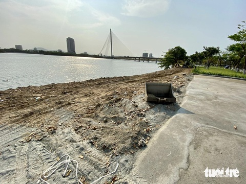Xà bần đổ lấn sông Hàn gần cầu Trần Thị Lý Đà Nẵng- Ảnh 1. Vệt xà bần được đổ ngoài bờ kè sông Hàn kéo dài hàng trăm mét - Ảnh: TRƯỜNG TRUNG