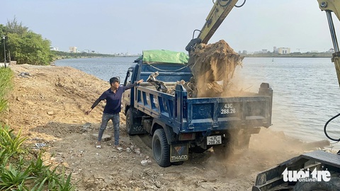 Xà bần đổ lấn sông Hàn gần cầu Trần Thị Lý Đà Nẵng- Ảnh 4. Chiều 5-4 có một xe múc đi xúc phần đất đá bị đổ tràn bên ngoài bờ kè sông - Ảnh: TRƯỜNG TRUNG