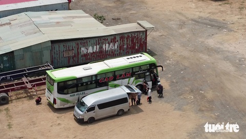 Tréo ngoe xe dù đón khách trong bãi container ở TP Thủ Đức- Ảnh 1. Nhà xe Cao Lâm điều xe trung chuyển chở hàng chục hành khách đến một bãi xe container, sau đó sang qua xe giường nằm ở phường Thạnh Mỹ Lợi - Ảnh: MINH HÒA