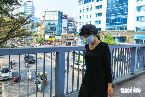 Khi nào Hà Nội mới hết 'mùa' ô nhiễm không khí?- Ảnh 1. Dù đi bộ nhưng người dân Hà Nội vẫn đeo khẩu trang để tránh bụi - Ảnh: DANH KHANG