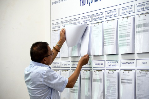 Lương hưu nên tăng bao nhiêu để đủ sống?- Ảnh 4. Người dân xem hướng dẫn thủ tục tham gia bảo hiểm xã hội tại TP.HCM - Ảnh: TỰ TRUNG