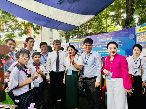 Bất ngờ học sinh tiểu học làm hệ thống vườn cây thông minh mini- Ảnh 3. Thầy cô, khách mời thích thú chụp hình với ba học sinh tiểu học thực hiện hệ thống Vườn cây thông minh mini tại Ngày hội STEM - Ảnh: MỸ DUNG
