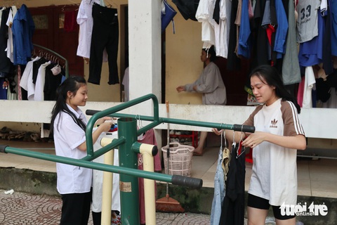 Ký túc xá cho học sinh dân tộc nội trú ‘vướng’ phần đất cho thầy cô mượn- Ảnh 1. Các em học sinh ở trong khu ký túc xá chật chội, quần áo giăng kín lối đi - Ảnh: DOÃN HÒA