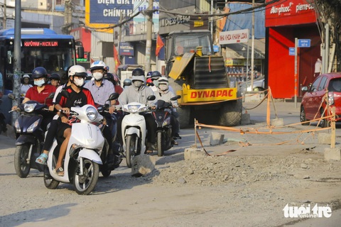 Cát bụi bao trùm tuyến đường Võ Văn Ngân, TP Thủ Đức, 'tấn công' người dân- Ảnh 6. Cát, đá, khối bê tông nằm lăn lóc gây nguy hiểm cho người đi đường - Ảnh: TIẾN QUỐC