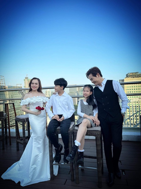 Hai con tuổi teen tặng quà bất ngờ kỷ niệm 25 năm ngày yêu và cưới của Hồng Phúc - Quỳnh Phượng- Ảnh 1. Bộ ảnh cưới mang gam màu tươi sáng như trắng, đỏ. Đặc biệt, trong bộ ảnh, còn có sự góp mặt của con trai Hồng Long (14 tuổi) và con gái Quỳnh Phương (10 tuổi) của cặp đôi.