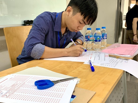 Có gì bên trong hội đồng thi đánh giá năng lực?- Ảnh 9. Cán bộ coi thi ký tên trên tờ phiếu trả lời trắc nghiệm trước khi phát cho thí sinh.