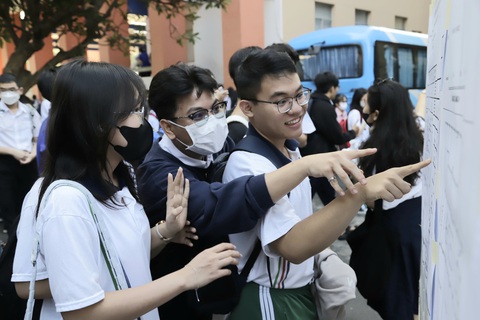 Thí sinh dự thi đánh giá năng lực 'đông nhất lịch sử'- Ảnh 8. Thí sinh xem danh sách phòng thi trước khi vào làm thủ tục - Ảnh: NHƯ HÙNG
