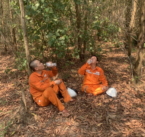 Ngày nắng theo chân người thợ đường dây- Ảnh 2. Tranh thủ giải khát sau ca làm việc cật lực - Ảnh: Quốc Ân
