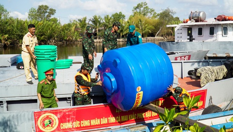 Tàu quân đội chở hơn 1.700m³ nước ngọt cấp cho người dân Cà Mau- Ảnh 3. Ngoài cấp nước, lực lượng chức năng còn cấp bồn nhựa cho người dân trữ lại - Ảnh: THANH HUYỀN