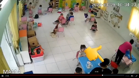 TP.HCM: Tạm đình chỉ cô giáo mầm non trong video đánh trẻ trong giờ ăn- Ảnh 2. Cô giáo mầm non (áo đen) tát vào mặt trẻ trong buổi ăn trưa ngày 29-3 - Ảnh cắt từ video