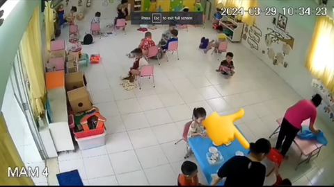 TP.HCM: Tạm đình chỉ cô giáo mầm non trong video đánh trẻ trong giờ ăn- Ảnh 3. Trẻ ngã dúi dụi sau khi bị cô giáo (áo đen) tát vào mặt lúc ăn trưa - Ảnh cắt từ video - Ảnh: MỸ DUNG