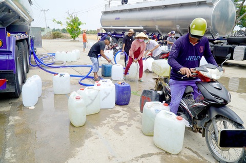 Người dân nhiều tỉnh Đồng bằng sông Cửu Long cho rằng xâm nhập mặn tăng gấp 3 lần- Ảnh 1. Người dân huyện Gò Công Đông (Tiền Giang) đến các xe chở nước sạch miễn phí cung cấp cho bà con - Ảnh: MẬU TRƯỜNG