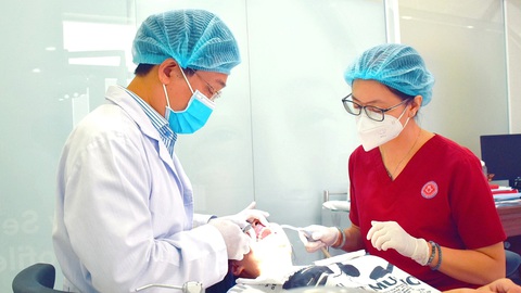 Muốn chỉnh nụ cười đẹp như diễn viên, đừng nghe theo quảng cáo linh tinh- Ảnh 1. Bác sĩ khoa chỉnh hình răng mặt Bệnh viện Răng Hàm Mặt TP.HCM đang điều trị cho bệnh nhân - Ảnh: V. Thảo