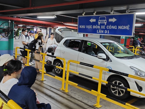 Taxi và xe công nghệ đua 'dàn quân' đầy bãi chờ ở sân bay Tân Sơn Nhất- Ảnh 4. Tại làn xe công nghệ, hành khách xếp hàng chờ đón xe - Ảnh: CÔNG TRUNG