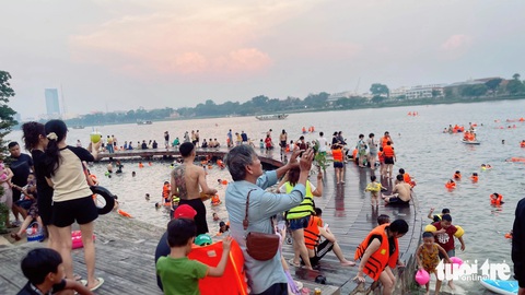Huế nắng nóng kỷ lục, người dân cùng du khách ra sông Hương chèo sup, tắm mát- Ảnh 3. Khoảng 16h chiều, rất nhiều người dân và du khách tìm đến cầu Bán Nguyệt ở bờ bắc sông Hương để giải nhiệt - Ảnh: BẢO PHÚ
