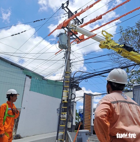 Vì sao cúp điện giữa những ngày nắng 'đổ lửa' ở Mỹ Tho, điện lực nói gì?- Ảnh 1. Các công nhân Công ty Điện lực Tiền Giang thực hiện lắp đặt trạm biến áp chống quá tải - Ảnh: HOÀI THƯƠNG