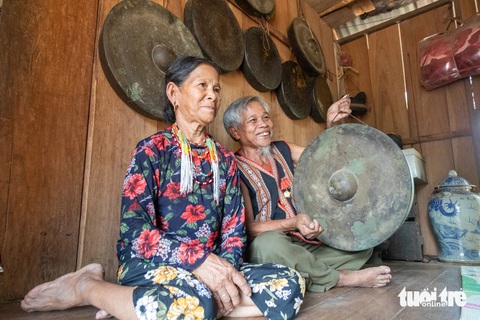 Giữ linh hồn cồng chiêng phía núi Trường Sơn- Ảnh 2. Ông Côn Bắt và vợ bên gia tài cồng chiêng của gia đình - Ảnh: HOÀNG TÁO