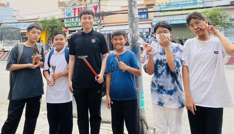9X học bằng hai sư phạm để đứng lớp học tình thương- Ảnh 2. Phan Trung Hải cùng các em lớp học tình thương tham gia xóa quảng cáo sai quy định - Ảnh: NVCC