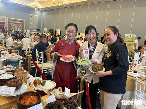 Bàn tiệc trưng bày hơn 100 loại mứt kẹo Việt Nam- Ảnh 2. Nghệ nhân Việt Nam giới thiệu các món mứt truyền thống với đầu bếp quốc tế - Ảnh: N.BÌNH