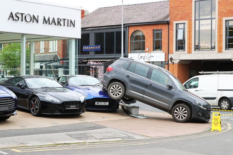 Méo mặt vì lùi trúng siêu xe Aston Martin giá trị gấp 20 lần- Ảnh 1. Hình ảnh cho thấy phần đuôi xe của chiếc Volkswagen màu xám nằm đè lên siêu xe thể thao đắt tiền - Ảnh: Eamonn & James Clarke