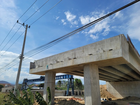 Cao tốc Vân Phong - Nha Trang 'vướng' nhiều trụ điện cao thế, hạ tầng kỹ thuật- Ảnh 3. Vướng đường điện, cầu vượt nút giao quốc lộ 26 chưa thể lắp đặt các dầm cầu còn lại - Ảnh: TRẦN HƯỚNG