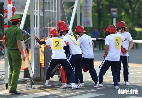 Sôi nổi tranh tài nghiệp vụ an toàn phòng cháy, chữa cháy- Ảnh 5. Các thí sinh đang phá khóa vào trong căn nhà cháy để cứu người - Ảnh: MINH HÒA