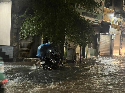 Hà Nội mưa to hàng giờ, đường phố bắt đầu ngập- Ảnh 2. Người dân hì hục dắt xe máy qua khu vực ngập sâu - Ảnh: PHẠM TUẤN