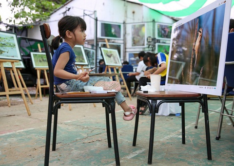 Một cô bé tiểu học đang vẽ. ảnh: Đào Quốc Bình Một cô bé tiểu học đang vẽ - Ảnh: Đào Quốc Bình