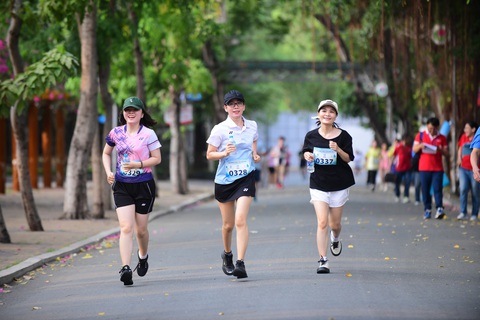 Sôi nổi Giải chạy bộ hưởng ứng Tháng Công nhân- Ảnh 6. Các nữ VĐV trên đường chạy 3km luôn thường trực nụ cười trên môi - Ảnh: Q.Đ