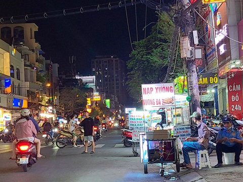 Bước ra ngõ gặp hàng rong, tuyên truyền hay xử phạt thật nặng?- Ảnh 1. Mời chào mua hàng của người bán hàng rong và các xe đẩy trên đường Nguyễn Gia Trí, quận Bình Thạnh - Ảnh: NHẬT XUÂN