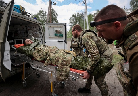 Lực lượng quân y Ukraine chữa trị một binh sĩ bị thương gần thị trấn Vovchansk, khu vực Kharkov ngày 12-5 - Ảnh: REUTERS Lực lượng quân y Ukraine chữa trị một binh sĩ bị thương gần thị trấn Vovchansk, khu vực Kharkov ngày 12-5 - Ảnh: REUTERS