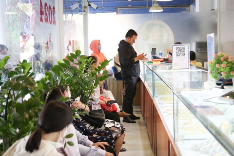 Giá vàng sáng giảm chiều tăng, người dân vẫn xếp hàng mua bán- Ảnh 3. Khu vực mua bán thanh toán bằng chuyển khoản cũng đông khách hàng xếp hàng chờ vòng trong vòng ngoài - Ảnh: PHƯƠNG QUYÊN