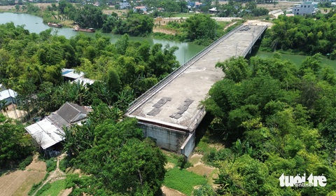 Bi hài hàng loạt cây cầu ở Quảng Nam xây xong đã lâu, chưa thấy đường dẫn- Ảnh 5. Phần đường dẫn cầu bắc qua sông Vĩnh Điện ở phía phường Điện Minh vẫn um tùm cây và nhà dân - Ảnh: LÊ TRUNG
