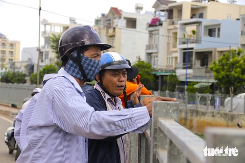 Ra quân 'giải cứu' kênh Nước Đen ngập ngụa rác- Ảnh 10. Người dân bày tỏ sự vui mừng khi đoạn kênh Nước Đen ô nhiễm cạnh nhà mình đang được xử lý, dọn dẹp - Ảnh: TIẾN QUỐC