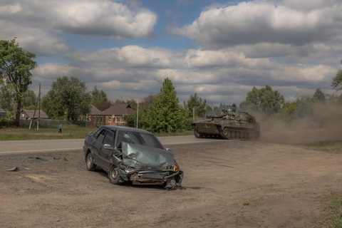 Ukraine thay chỉ huy lực lượng bảo vệ Kharkov- Ảnh 1. Pháo tự hành 2S1 Gvozdika của Ukraine băng qua một chiếc ô tô bị hư hỏng trên đường phố ở Vovchansk, vùng Kharkov, đông bắc Ukraine, ngày 12-5 - Ảnh: AFP