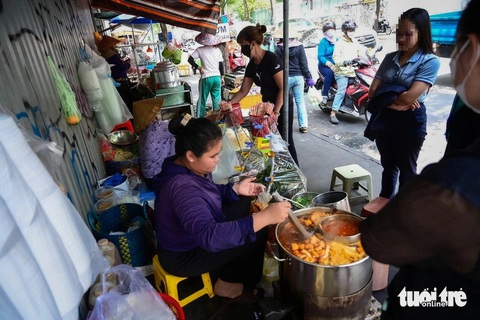 Giới trẻ đô thị: Cả tháng nấu ăn 1 lần, coi chừng sinh bệnh vì ăn linh tinh- Ảnh 1. Nhân viên văn phòng tại trung tâm TP.HCM chuộng các gánh hàng rong. Trong ảnh: khách chờ mua canh bún tại một gánh vỉa hè trên đường Hai Bà Trưng (quận 1) - Ảnh: PHƯƠNG QUYÊN