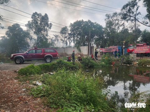 Cháy bãi chứa đồ phế liệu ở quận Bình Tân, cột khói đen cao hàng chục mét- Ảnh 4. Cảnh sát đã dùng máy bơm công suất lớn bơm nước trực tiếp dưới kênh gần đó để chữa cháy - Ảnh: NGỌC KHẢI