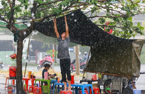 Tin mừng TP.HCM sắp mưa nhiều mưa lớn- Ảnh 3. Người dân buôn bán che chắn tạm để tránh mưa - Ảnh: LÊ PHAN