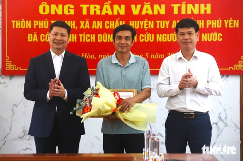 Chủ tịch UBND TP Tuy Hòa Cao Đình Huy (ngoài cùng bên trái) trao bằng khen cho anh Trần Văn Tính (giữa) vì có hành động dũng cảm cứu người bị đuối nước - Ảnh: NGUYỄN HOÀNG Chủ tịch UBND TP Tuy Hòa Cao Đình Huy (bìa trái) trao giấy khen cho anh Trần Văn Tính (giữa) vì có hành động dũng cảm cứu người bị đuối nước - Ảnh: NGUYỄN HOÀNG