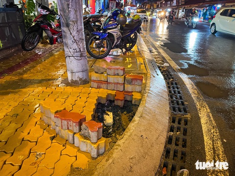 Cống bung, đường vỡ sau mưa lớn, điều gì xảy ra với dự án Võ Văn Ngân mới 20 ngày khánh thành?- Ảnh 5. Gạch vỉa hè còn rất mới đã bị bong tróc. Người dân lo ngại những vị trí này sẽ bị sụt lún - Ảnh: LÊ PHAN