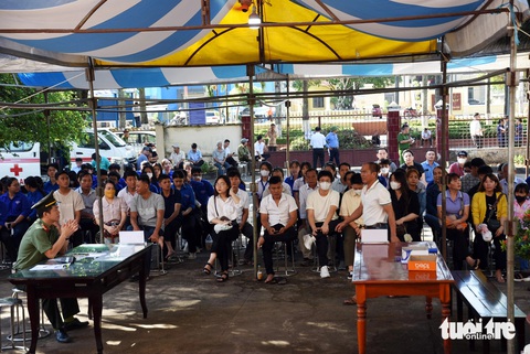 Xét xử phó giám đốc nhà xe Thành Bưởi và tài xế vụ tai nạn làm chết 5 người- Ảnh 2. Cán bộ, thanh niên và người dân địa phương theo dõi phiên tòa thông qua một màn hình lớn dựng trước sân tòa - Ảnh: A LỘC