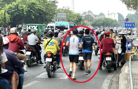 Biết nguy hiểm, sao vẫn chen chân chạy bộ dưới lòng đường?- Ảnh 1. Hai người chạy bộ len lỏi giữa dòng xe trên đường Hoàng Minh Giám, quận Gò Vấp - Ảnh: XUÂN ĐOÀN