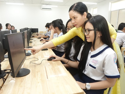 TP.HCM tăng hơn 5.500 chỉ tiêu tuyển sinh lớp 10- Ảnh 1. Giáo viên chủ nhiệm lớp 9/11 Trường THCS Kim Đồng, Q.5, TP.HCM hướng dẫn học sinh cách đăng ký tuyển sinh lớp 10 sáng 6-5 - Ảnh: NHƯ HÙNG