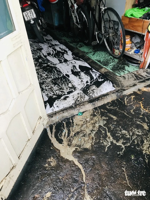 Mưa kéo nước cống, bùn đen tràn vào hàng chục nhà dân ở Đà Nẵng- Ảnh 5. Bùn đen ngòm đọng trên nền nhà khi nước rút
