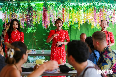Ngồi tàu máy, đi xe điện khám phá cù lao ven sông Mekong- Ảnh 10. Thấy khách ghé vào, chủ nhà niềm nở đón chào rồi tiến ra vườn chọn những trái chín thơm ngon nhất, hái xuống cho mọi người thưởng thức ngay tại chỗ. Đến đây, nhiều người còn bị mê mẩn bởi những giai điệu đờn ca tài tử như