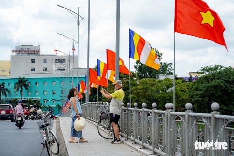 Ngắm ‘7 bước chân Phật’ trên sông Hương- Ảnh 7. Du khách người nước ngoài dừng chân trên cầu Phú Xuân chụp ảnh lưu niệm và chụp ảnh bảy đóa sen khổng lồ trên sông Hương - Ảnh: LÊ ĐÌNH HOÀNG
