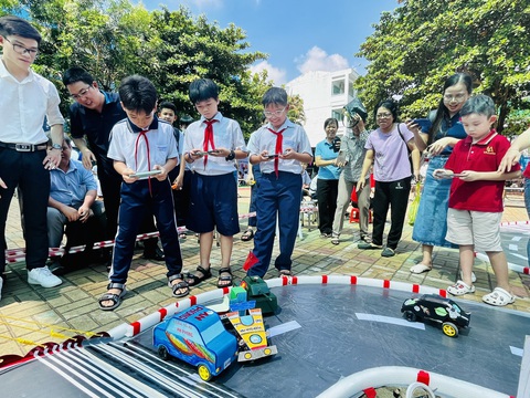 Học sinh hào hứng trải nghiệm làm 'công dân số'- Ảnh 1. Học sinh hào hứng thi đua xe mô hình tự điều khiển dưới sự cổ vũ của phụ huynh và các bạn - Ảnh: MỸ DUNG