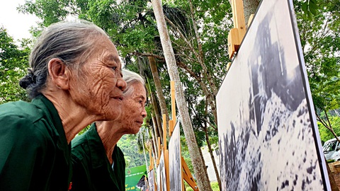65 năm đường Trường Sơn - đường Hồ Chí Minh huyền thoại- Ảnh 6. Bà Hoàng Thị Tinh (phía trước) và bà Phạm Thị Khuyển (cùng trú thị trấn Phong Nha, Bố Trạch, Quảng Bình) - hai nữ TNXP năm xưa vẫn tự hào qua hình ảnh tư liệu phá đá mở đường Trường Sơn huyền thoại